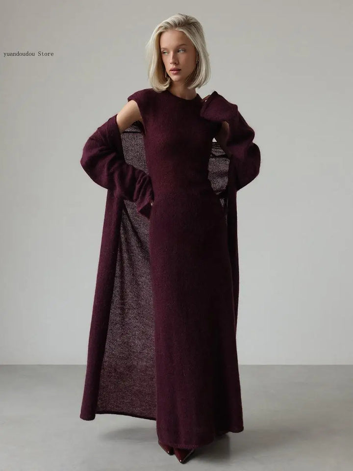 Woman wearing purple knit sweater dress with cutout shoulder duster