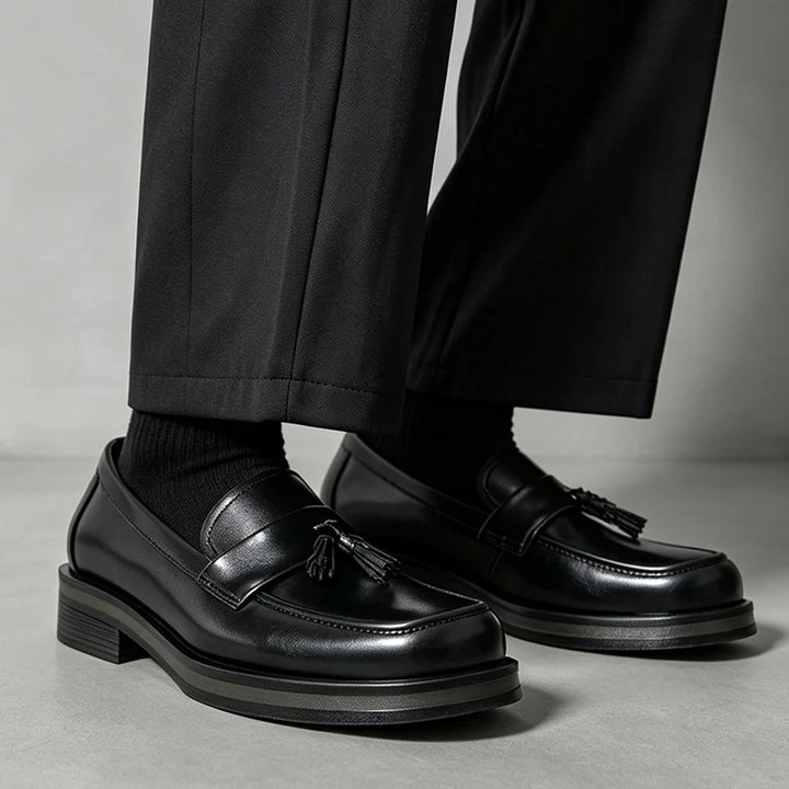 Man standing in black tassel loafers with black socks