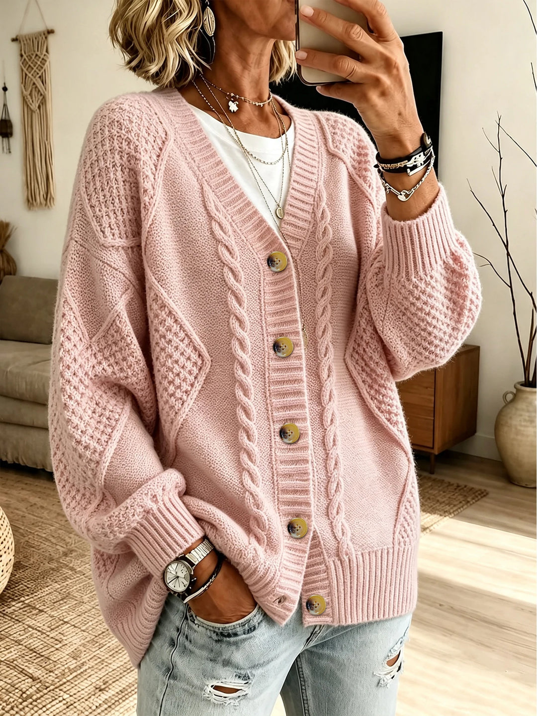 Woman wearing blush pink cable knit button front cardigan