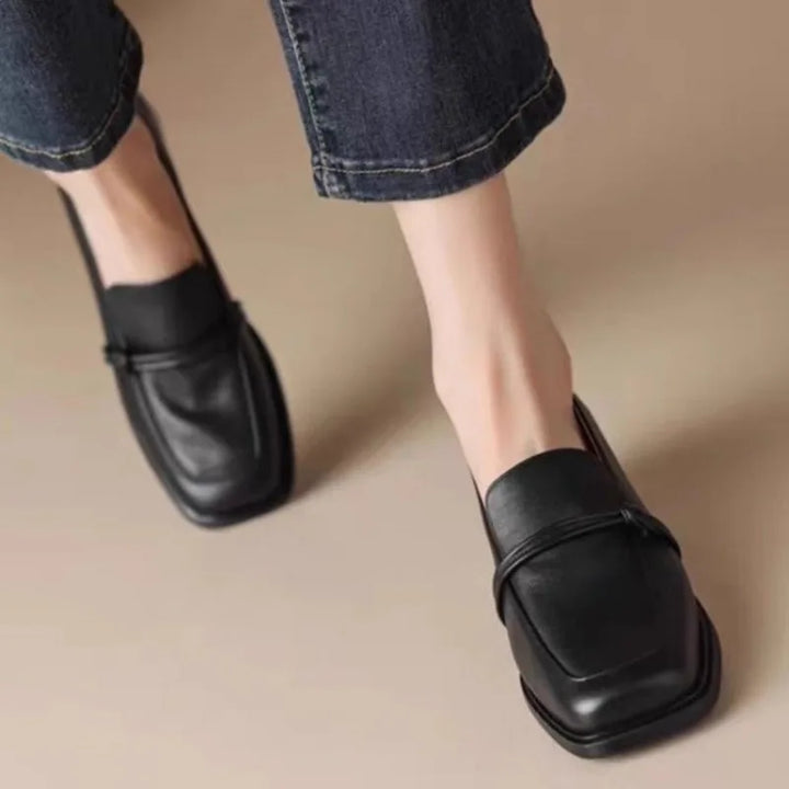 Black loafers worn walking with jeans