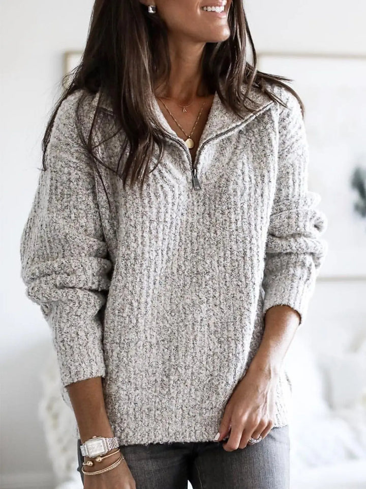 Woman wearing light gray textured knit quarter-zip sweater with stand collar