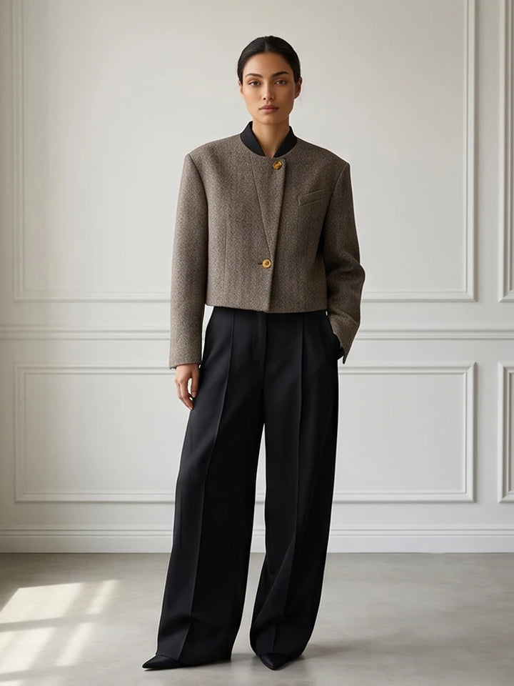 Grey herringbone cropped jacket styled with black wide leg trousers, full length front view
