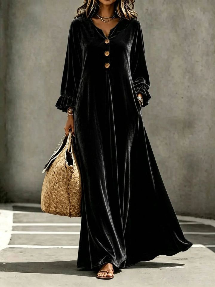 Woman wearing black velvet maxi dress with ruffled cuffs