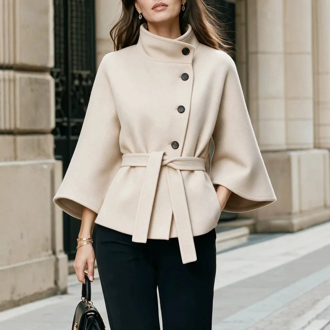 Woman wearing beige belted cape coat with stand collar