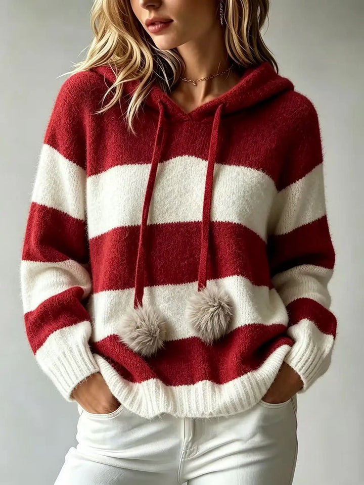 Woman wearing wine red and white striped hooded knit sweater with faux fur pom drawstrings