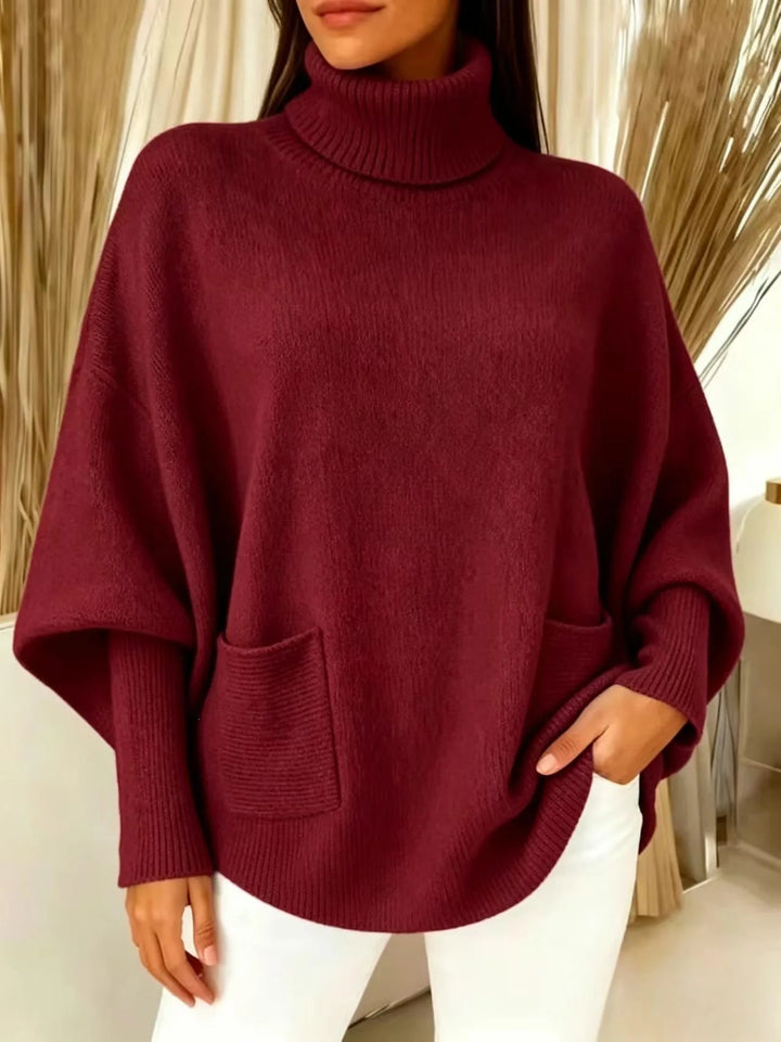 Woman wearing wine red turtleneck batwing sweater with front pocket