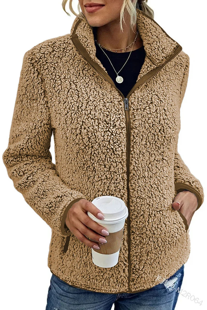 Woman wearing khaki sherpa fleece zip jacket holding coffee