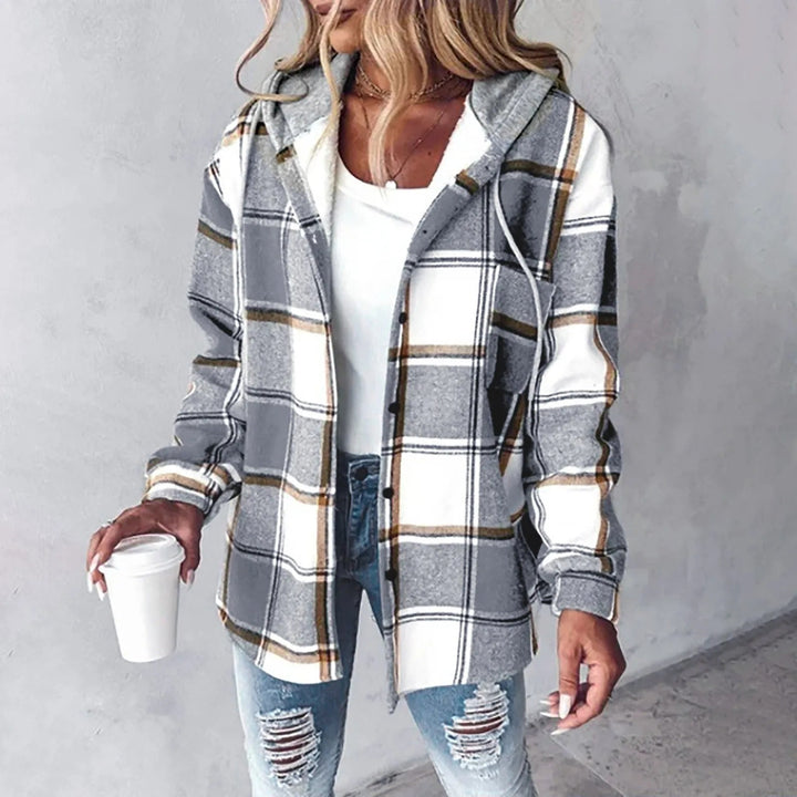 Woman wearing gray and white plaid flannel shacket with hood