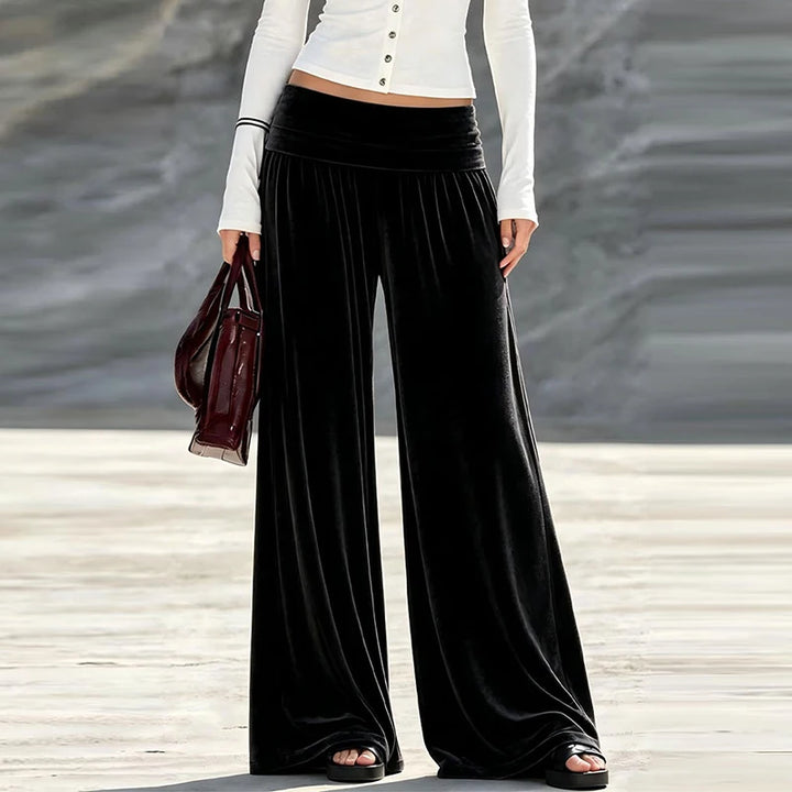 Woman wearing black velvet wide leg high waist pants, front view