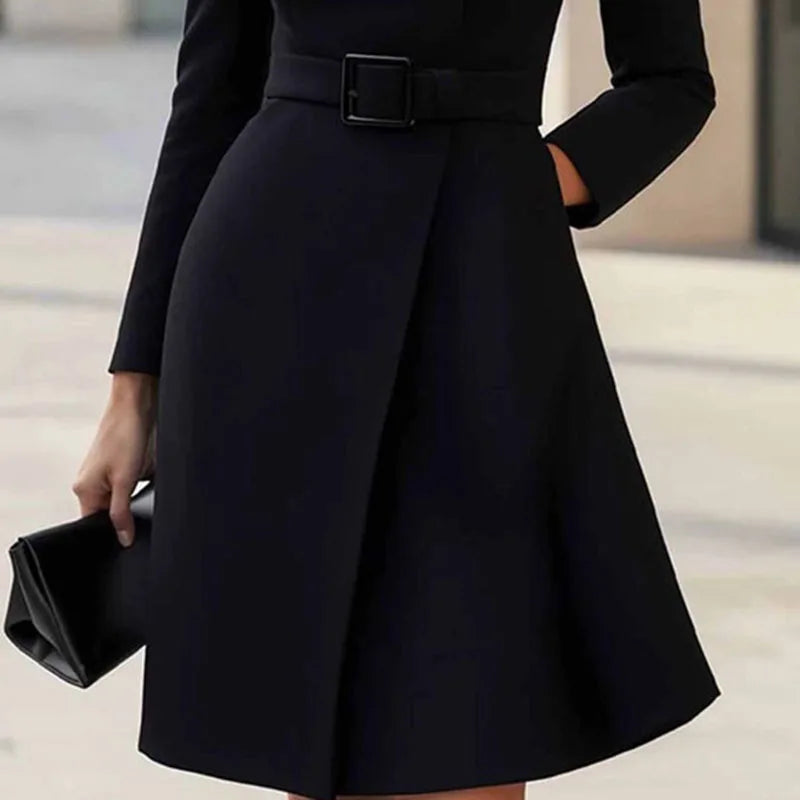 Black dress skirt detail showing wrap front hem and belted waist