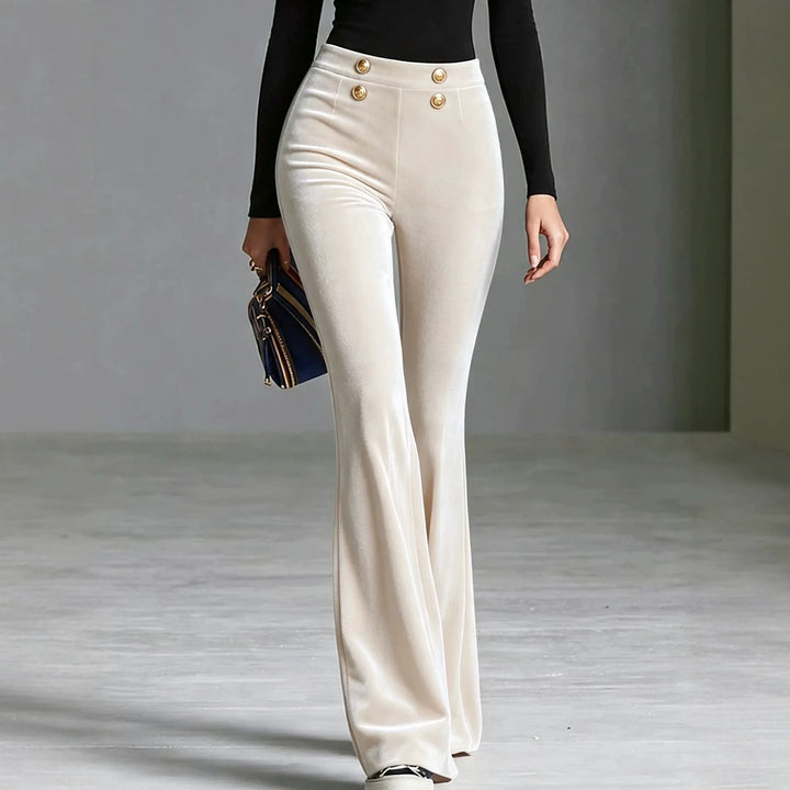 Woman wearing cream velvet flared high waist pants with gold buttons, front view