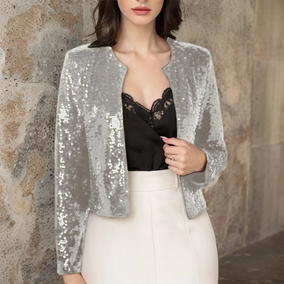Silver sequin cropped jacket worn open over black lace top