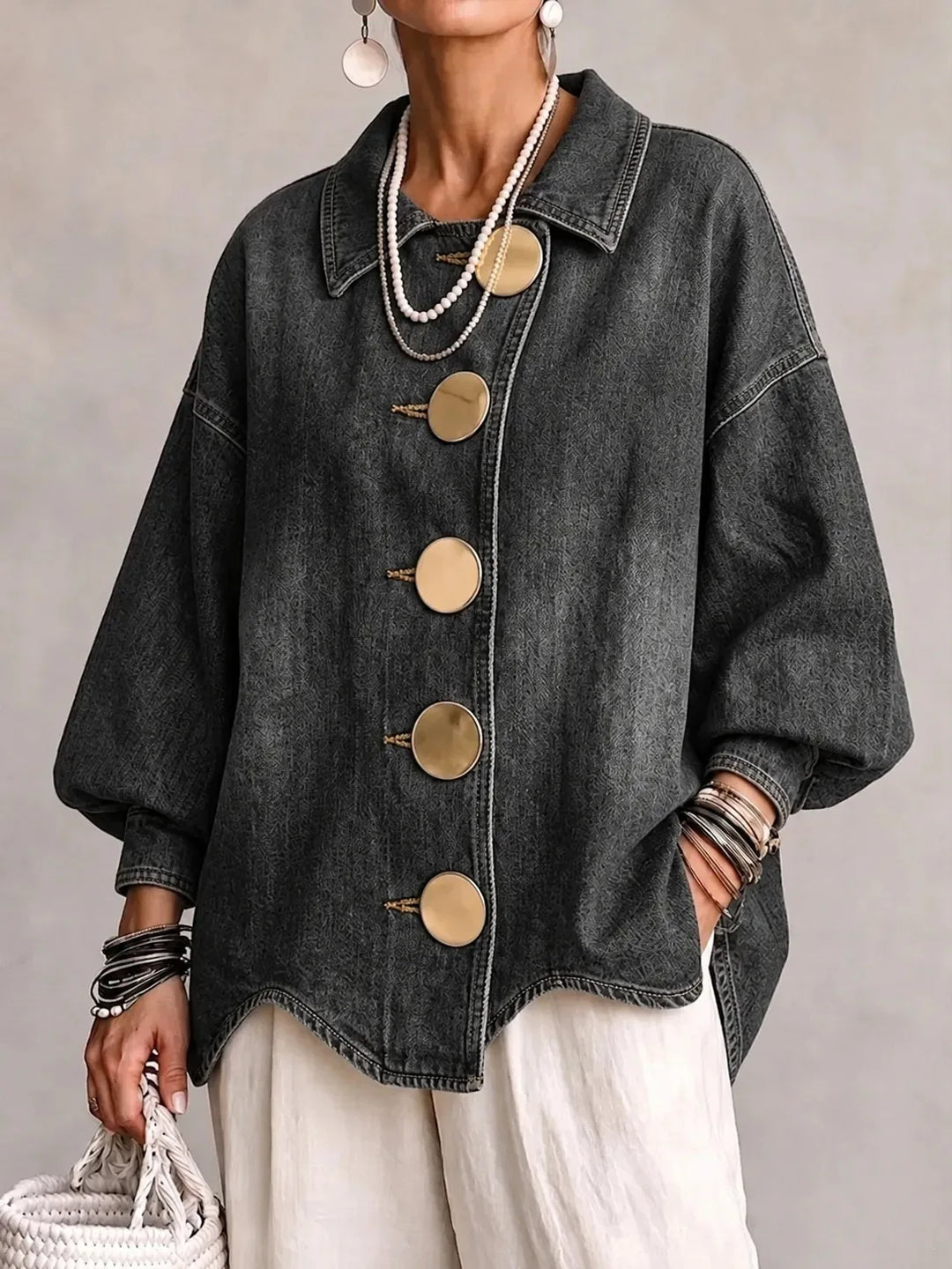Woman wearing gray denim jacket with large gold buttons, front view