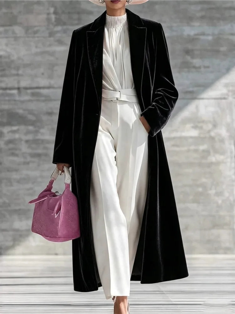 Woman wearing a black velvet maxi coat with notched lapel