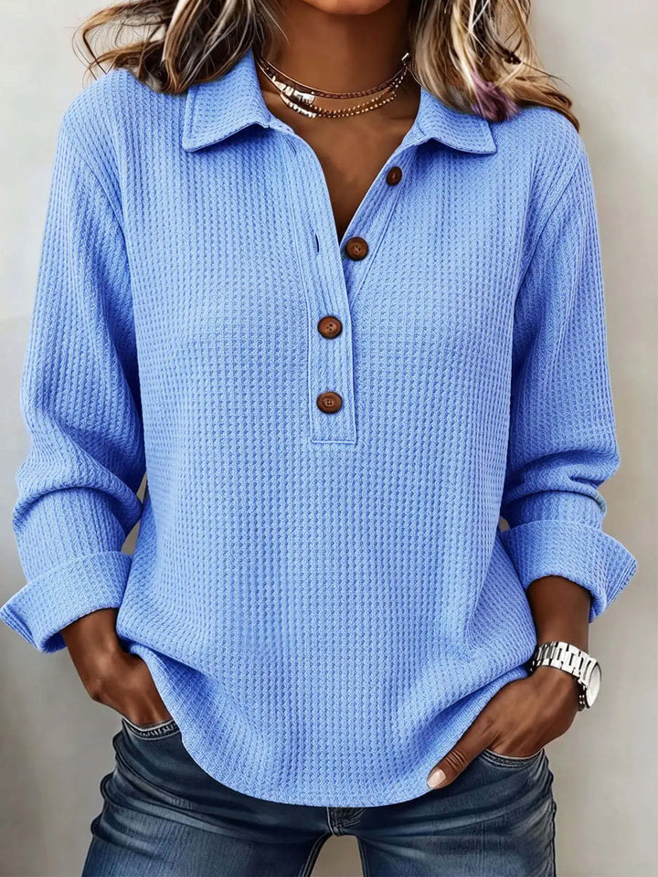 Close up of sky blue waffle knit top with brown buttons