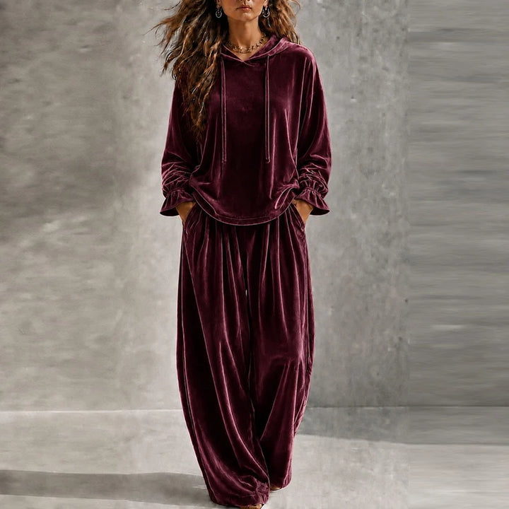 Woman wearing burgundy velvet hooded tracksuit with wide leg pants
