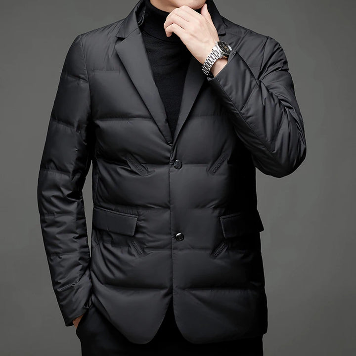 Man in black quilted down blazer jacket with hand near collar