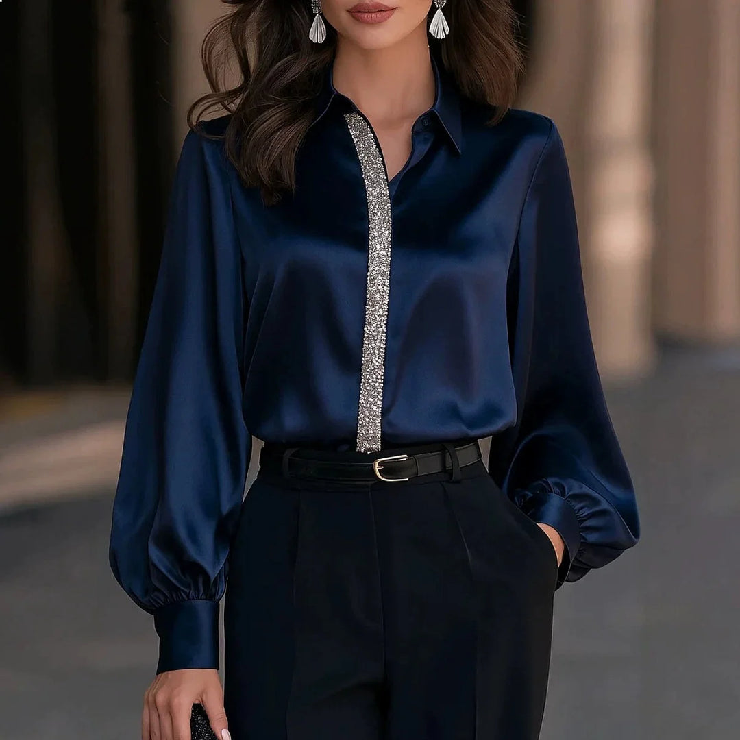 Woman wearing navy blue satin blouse with embellished trim