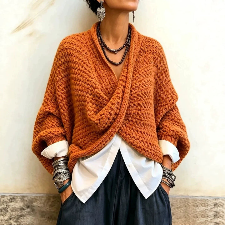 Woman wearing orange wrap front chunky knit cardigan over white shirt