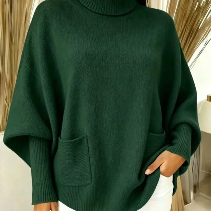 Woman wearing dark green turtleneck batwing sweater with front pocket