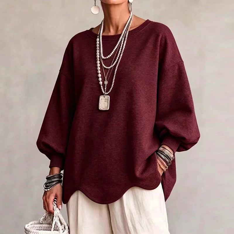 Woman wearing burgundy oversized sweatshirt with wavy hem