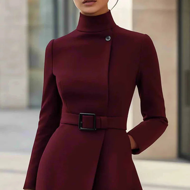 Close-up of wine red turtleneck dress bodice with button detail and belted waist