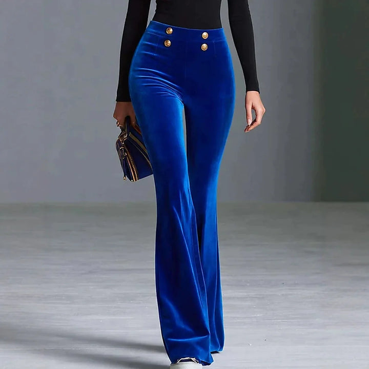 Woman wearing blue velvet flared high waist pants with gold buttons, front view