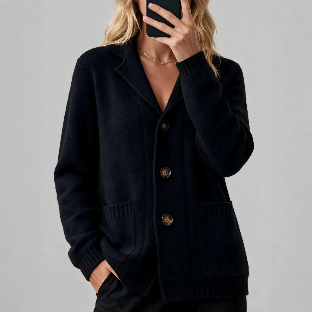 Woman wearing black waffle knit cardigan with notched lapel and buttons