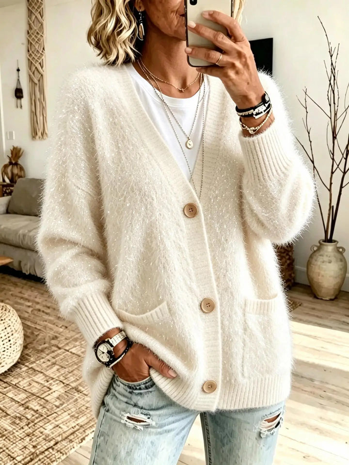 Close up of creamy white eyelash-knit cardigan with button closure