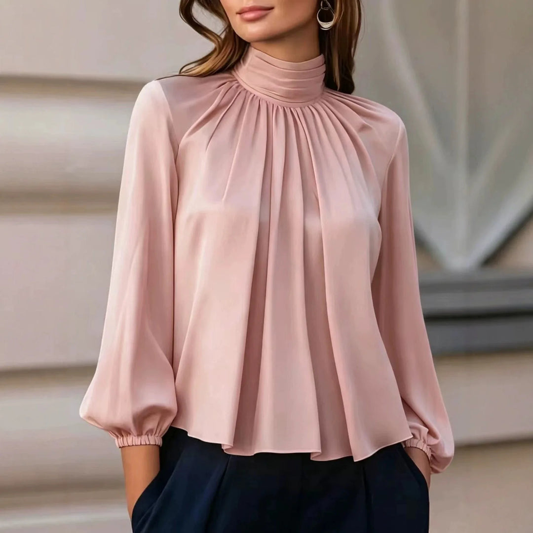 Woman wearing pink pleated mock neck blouse with bishop sleeves
