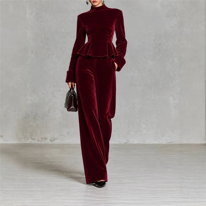 Woman wearing burgundy velvet peplum top and wide leg pants set, front view