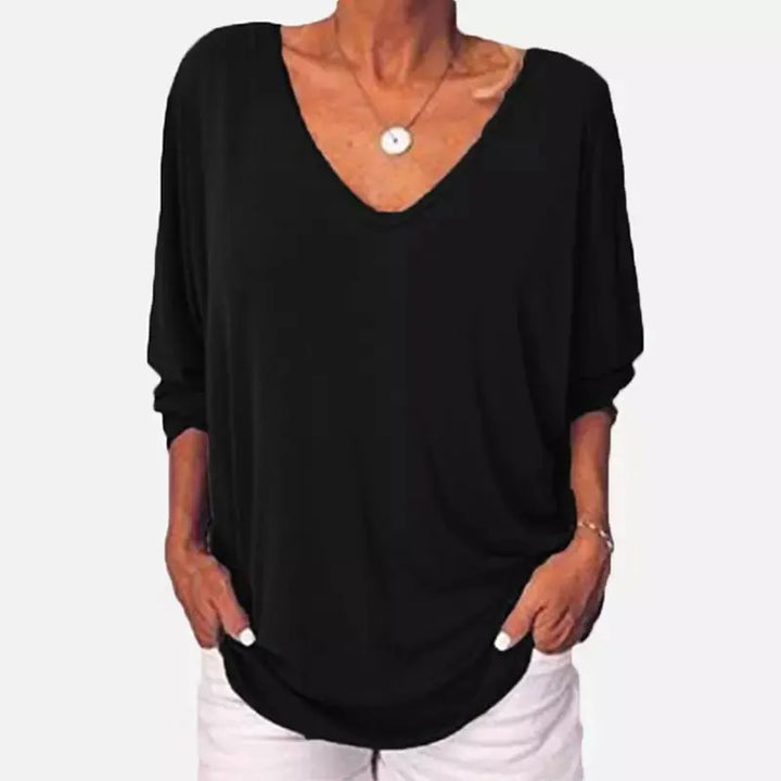 Woman wearing black V-neck three-quarter sleeve top, front view