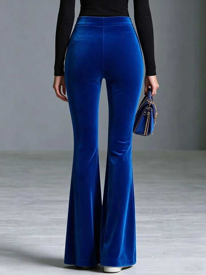 Woman wearing blue velvet flared pants, back view
