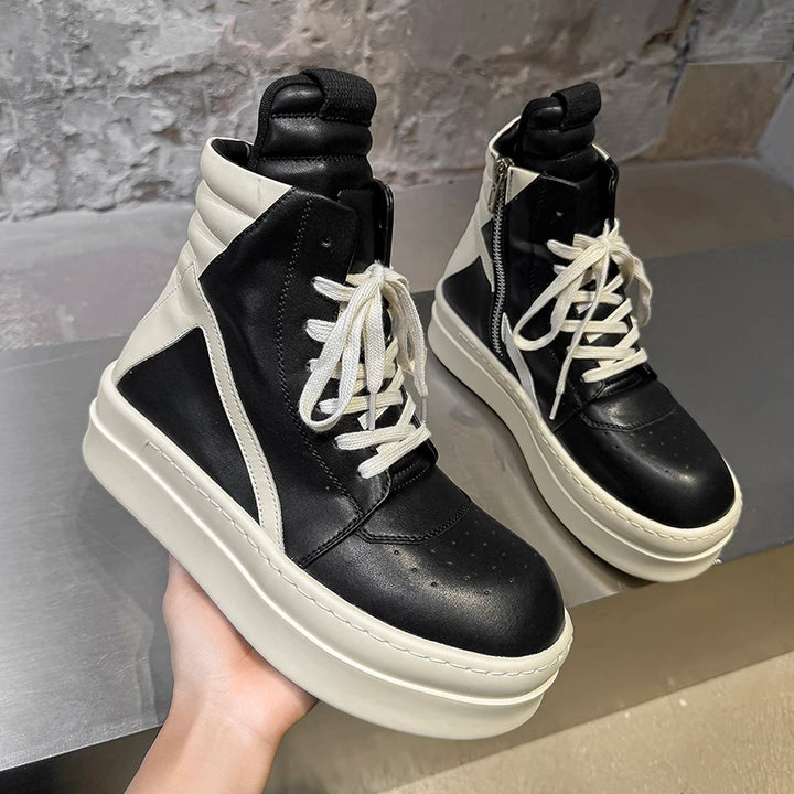 Black and white high top sneakers held in hand showing side panel detail