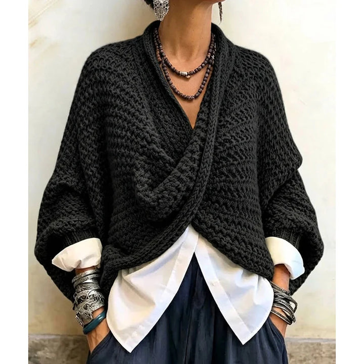 Woman wearing black wrap front chunky knit cardigan over white shirt