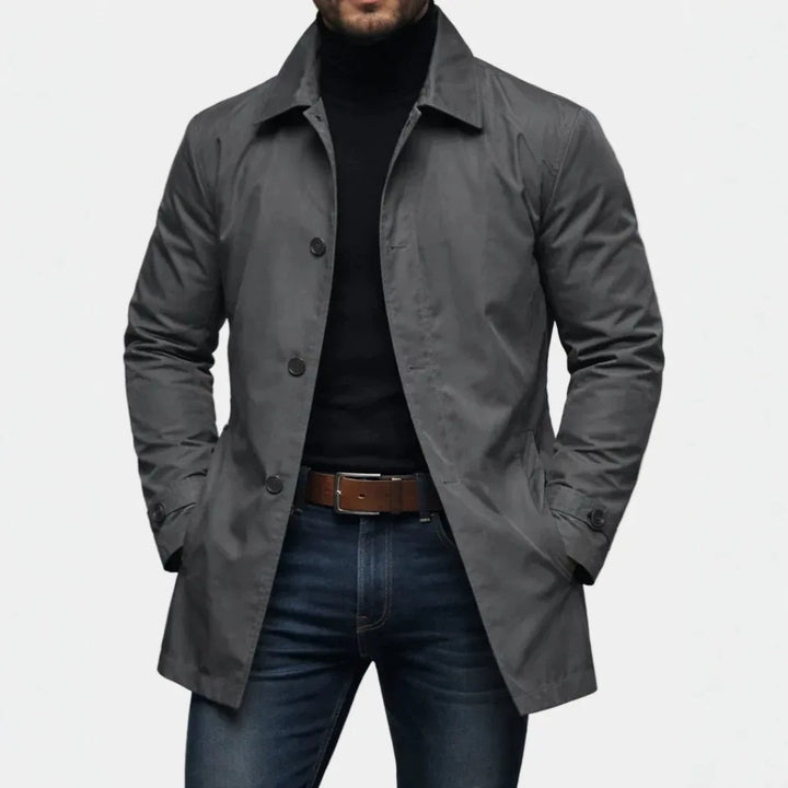 Man wearing gray mac-style trench coat with buttoned cuffs