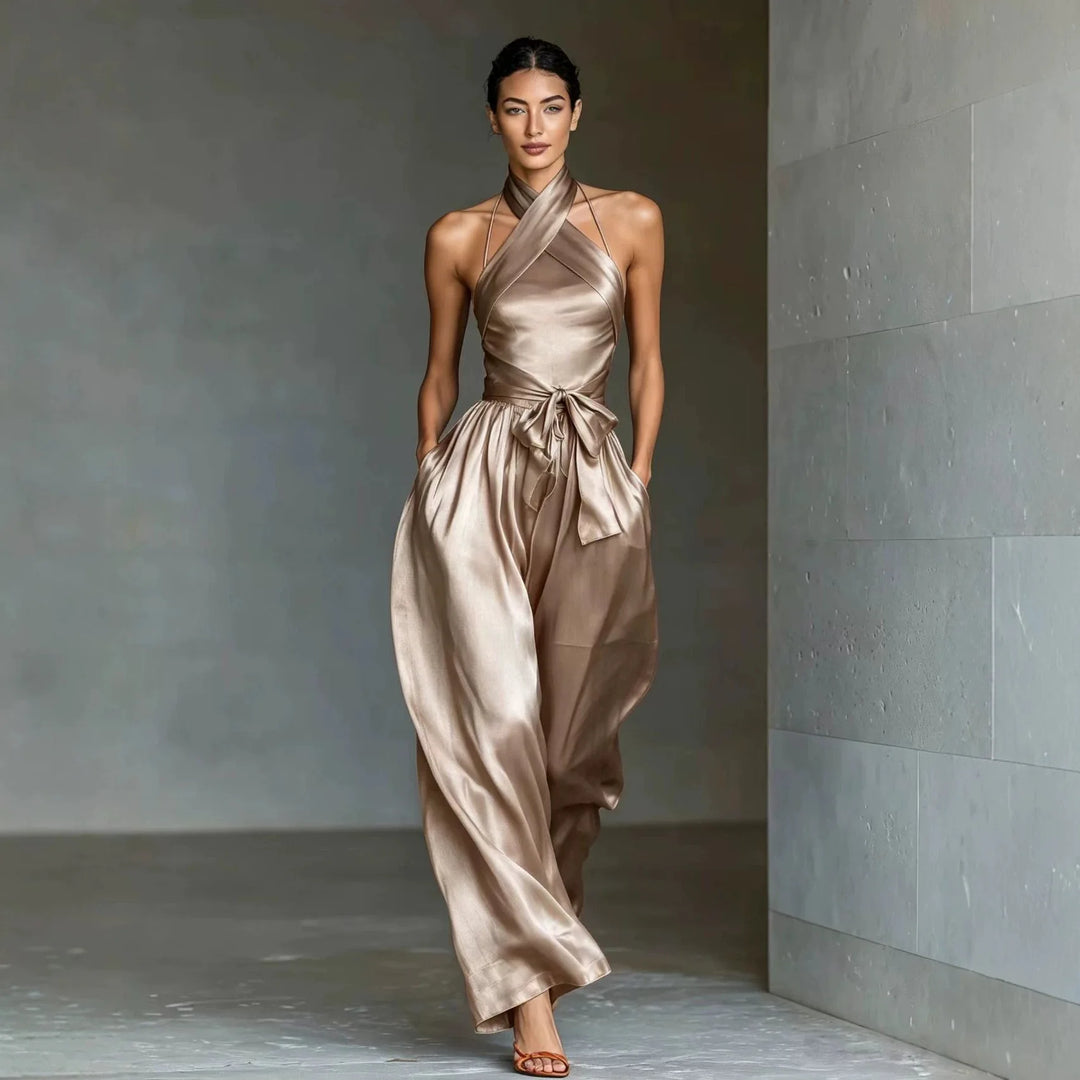 Woman wearing champagne satin halter jumpsuit with tie waist