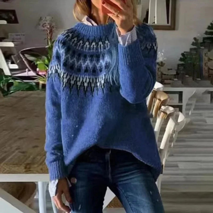 Woman wearing blue fair isle knit sweater with hands near face