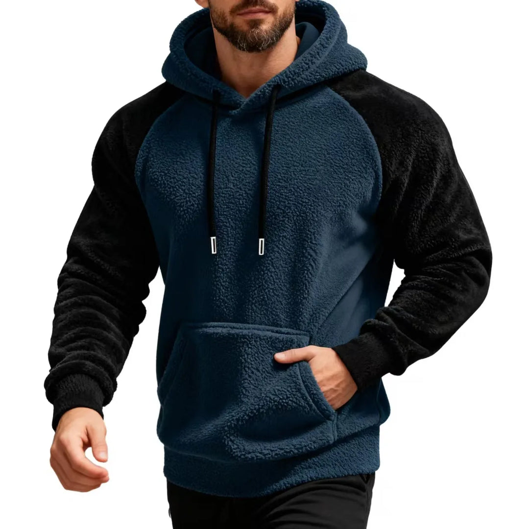 Man wearing navy blue and black sherpa fleece hoodie with kangaroo pocket