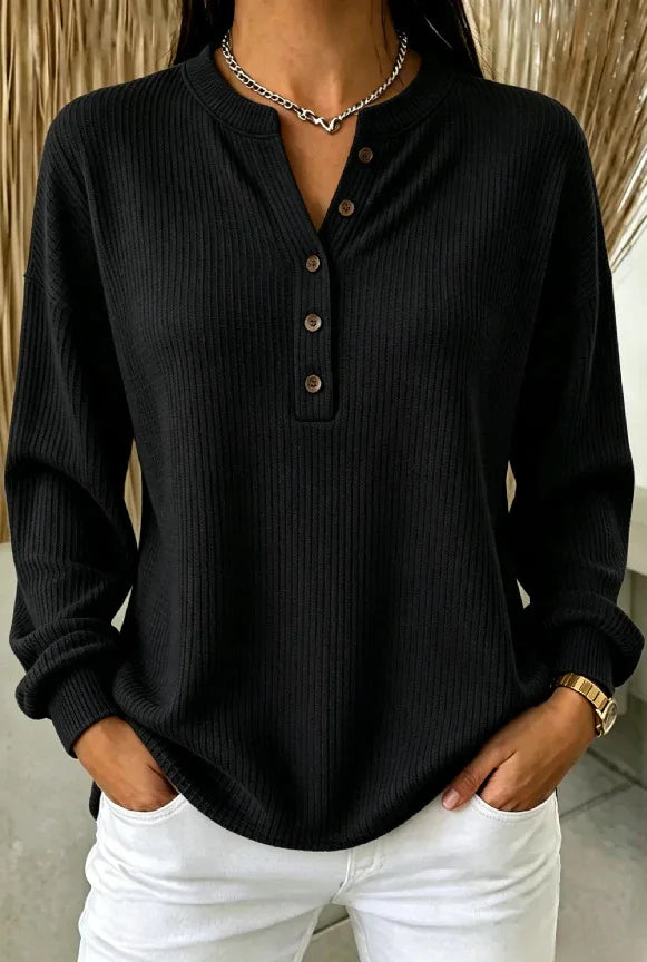 Woman wearing black ribbed knit henley top with button placket