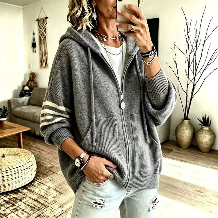 Woman wearing gray zip-up hoodie cardigan with striped sleeve detail