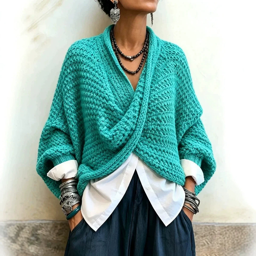 Woman wearing turquoise wrap front chunky knit cardigan over white shirt