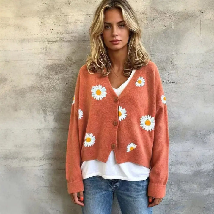 Woman wearing orange red daisy embroidered cardigan