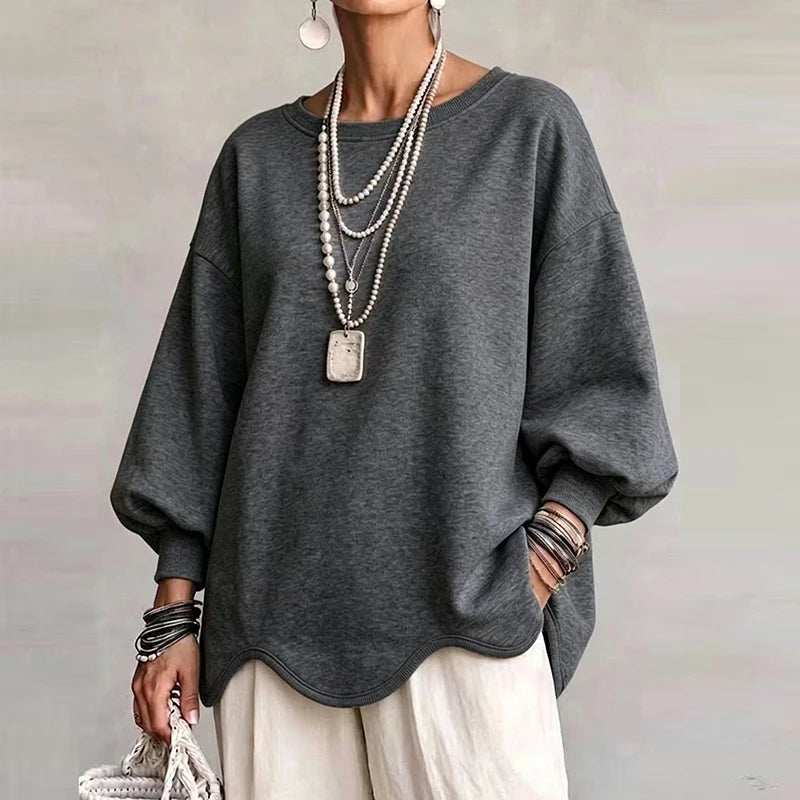Woman wearing charcoal gray oversized sweatshirt with wavy hem