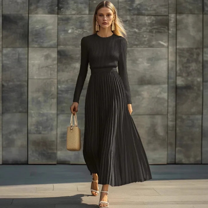 Woman wearing black ribbed knit pleated maxi dress, front view