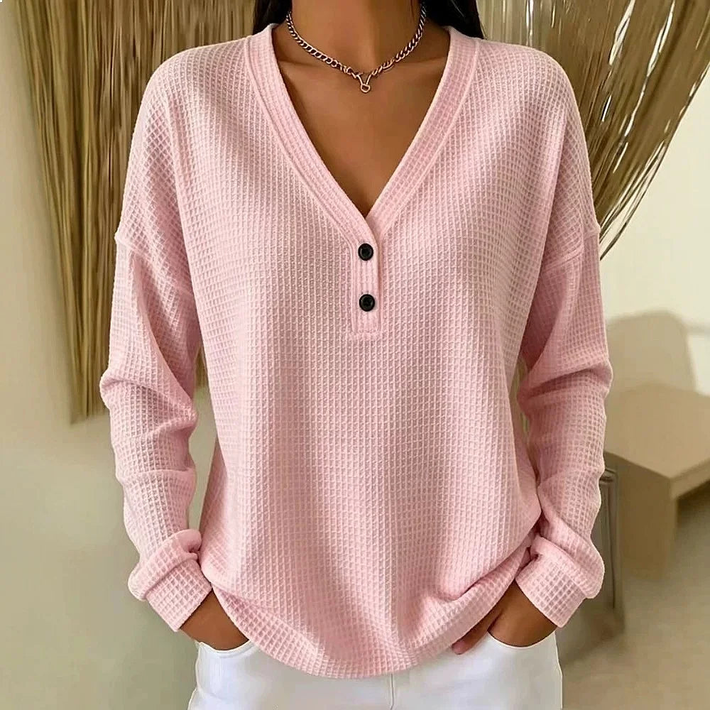 Woman wearing pink waffle knit V-neck henley top with button placket