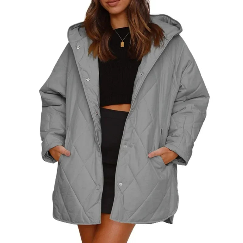 Woman wearing gray diamond quilted hooded jacket with hands in pockets