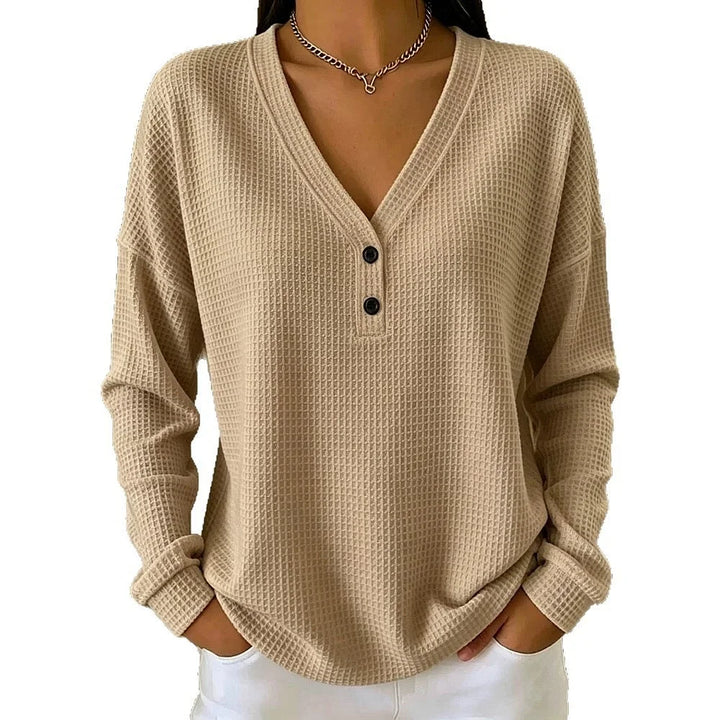 Woman wearing khaki waffle knit V-neck henley top with button placket