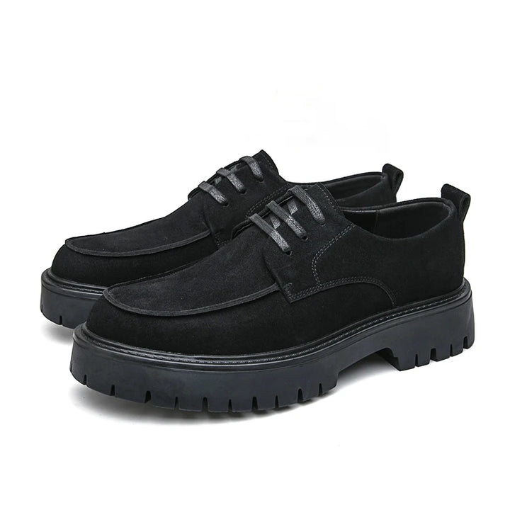 Pair of black suede platform oxford shoes on white background
