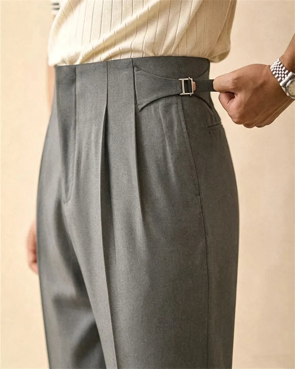 Close up of grey trousers with side buckle detail